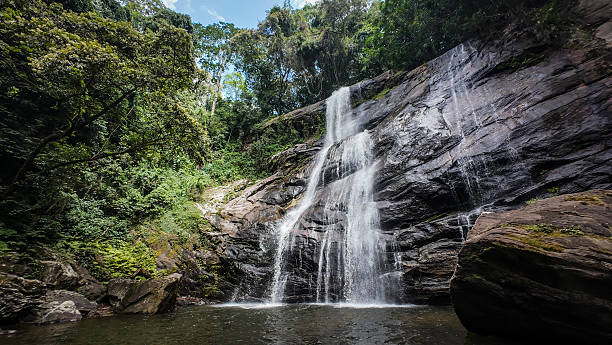 Sanje Waterfall cascading through lush forest